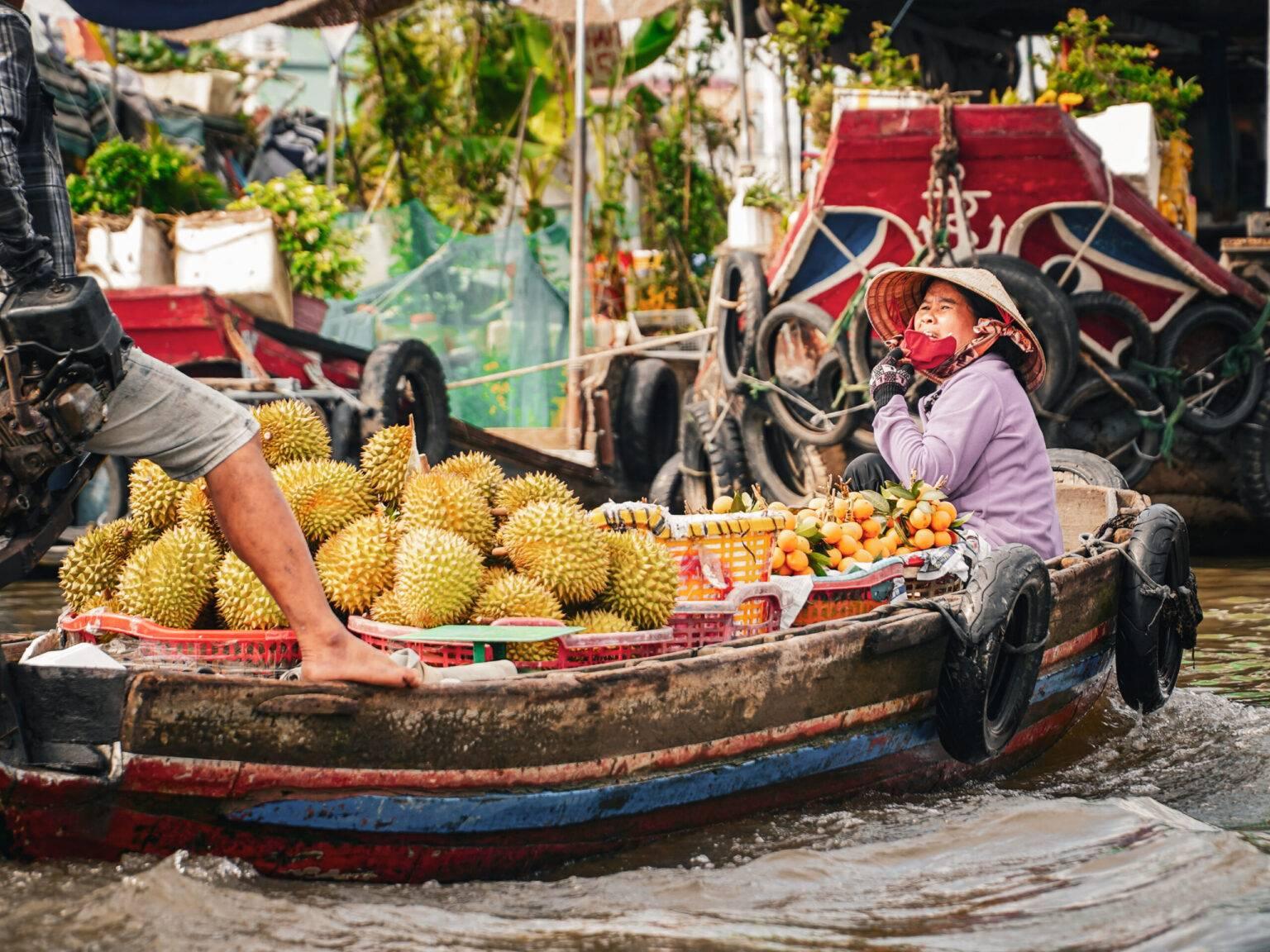 A boat with a vendor loaded with durian fruits at the Cai Rang floating market.