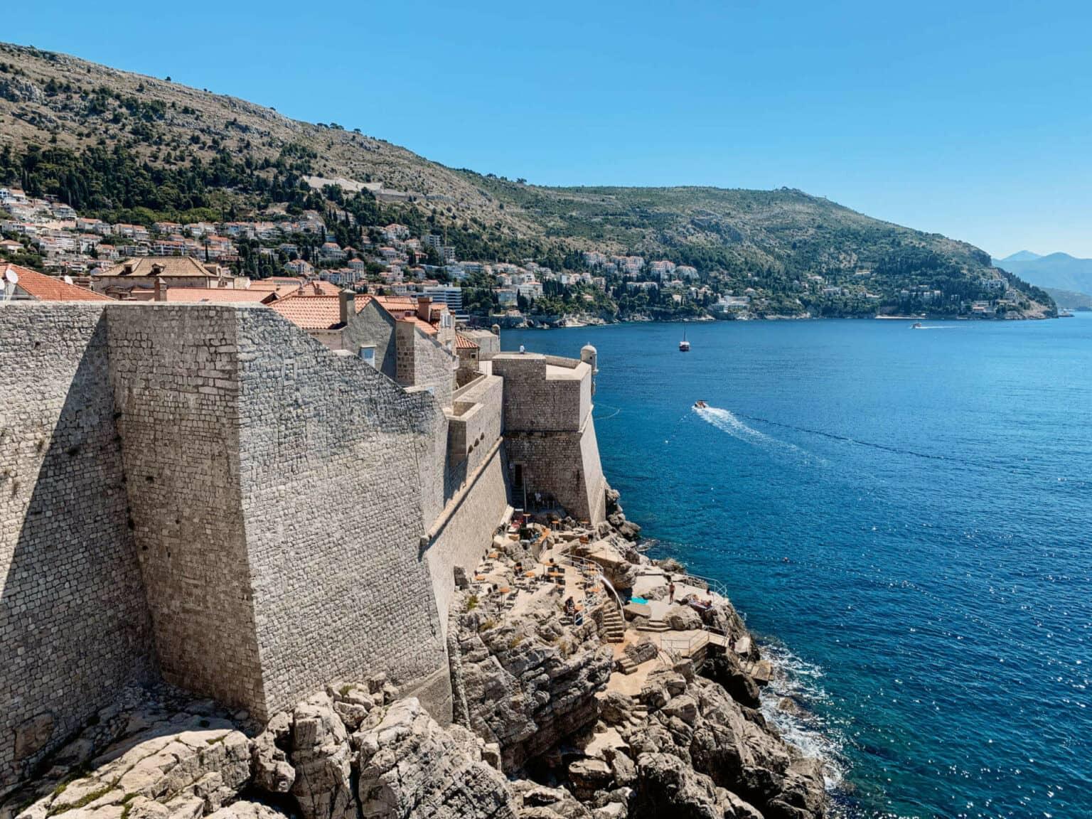 From Café Buža, you can enjoy a stunning view of the fortress walls built directly on the coast in Dubrovnik, Croatia.