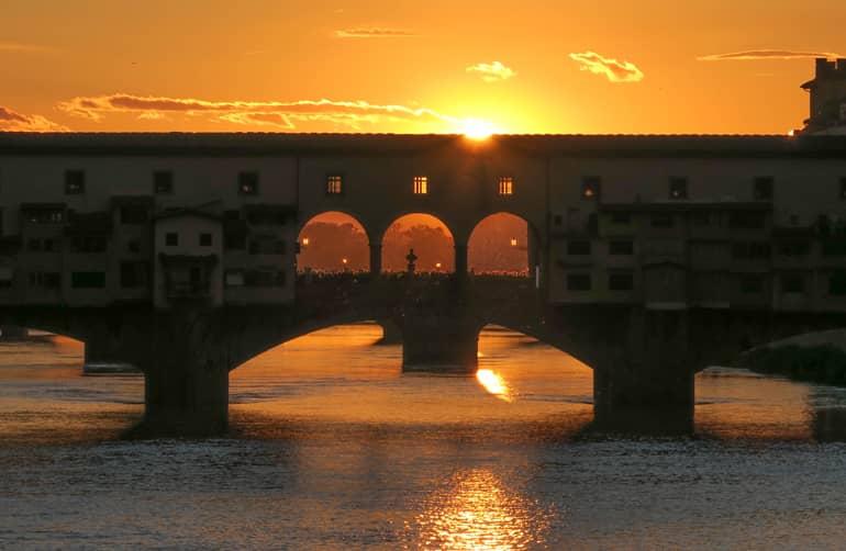 Consejos secretos de Florencia: Un puente sobre un río al atardecer.
