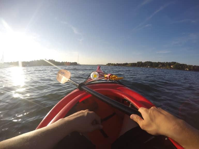 Un kayak rojo navega bajo el sol de la tarde en el archipiélago de Arkösund.