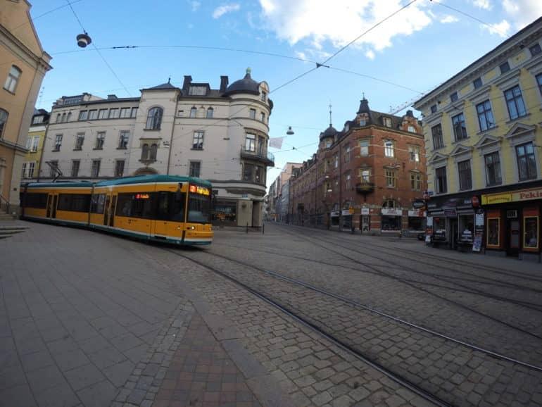 Un tranvía amarillo pasa por el casco antiguo empedrado de Norrköping.