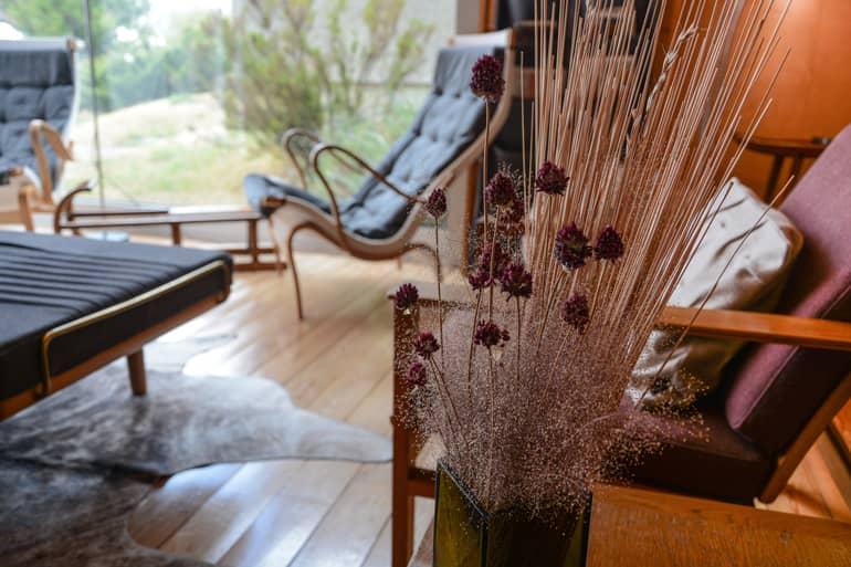 An armchair in front of a window with a plant.