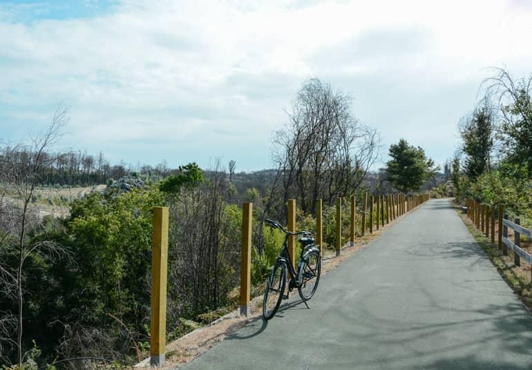 A path with a bicycle standing on it.