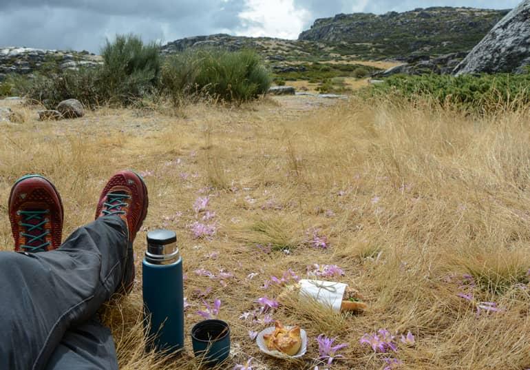 A person sitting on the ground, having a snack.