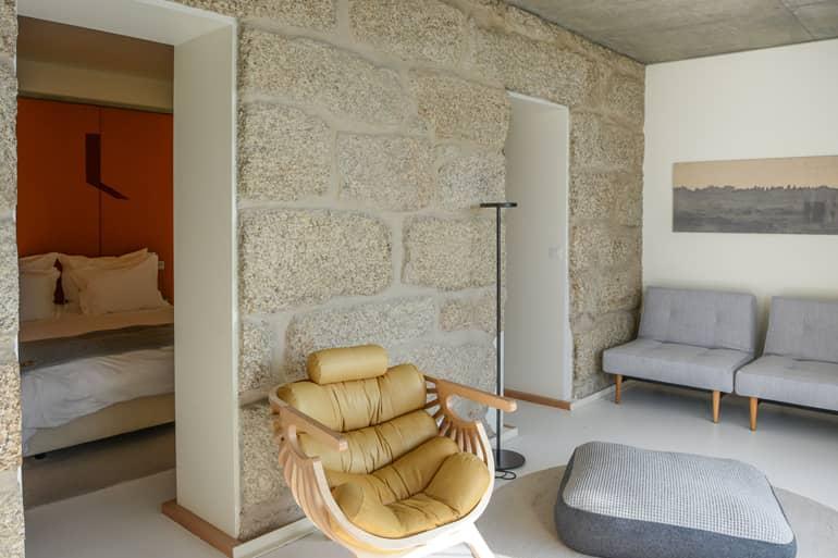 A stone wall with an armchair in front.
