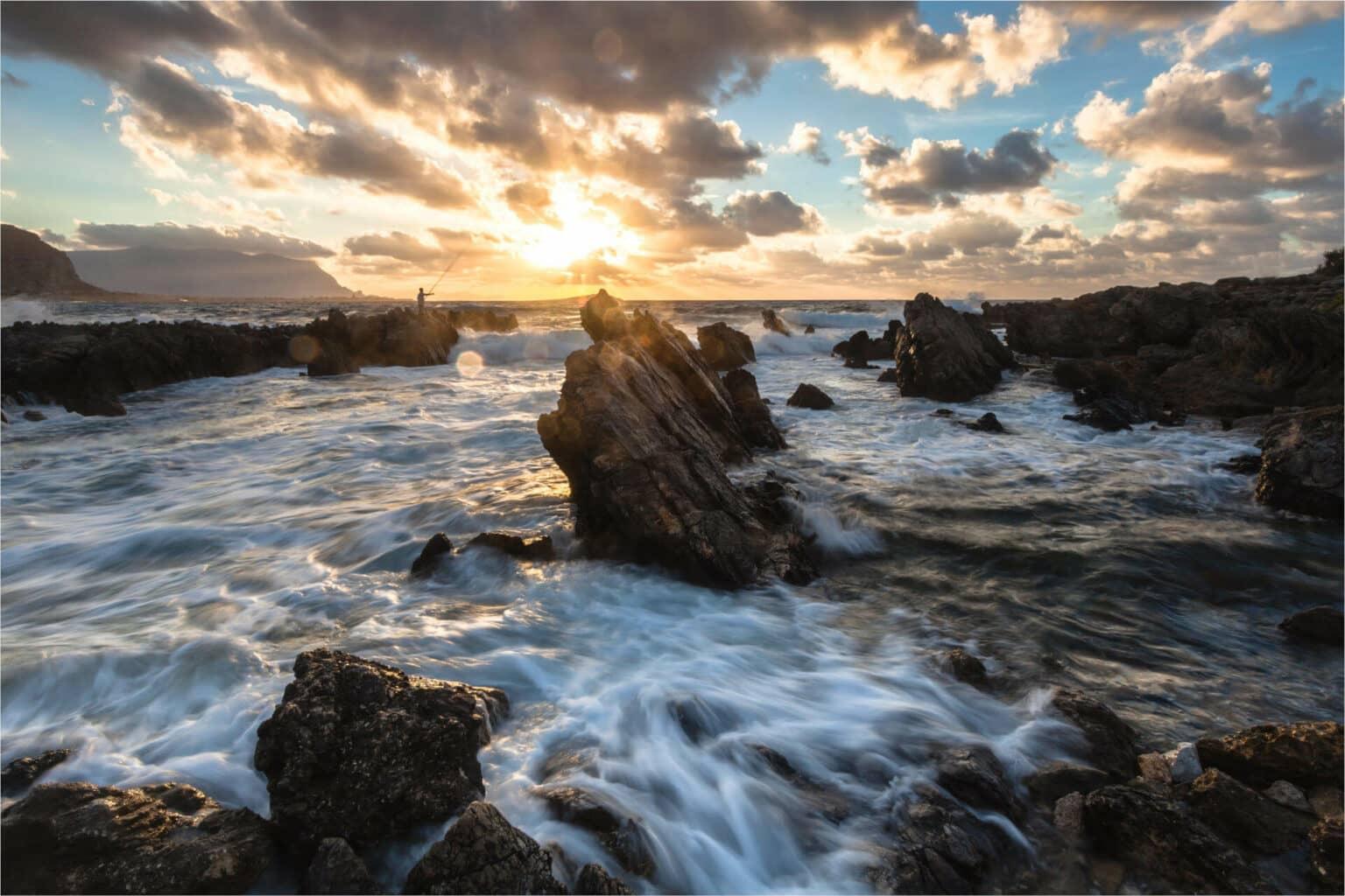A pier at the sea in Sicily at sunset.
