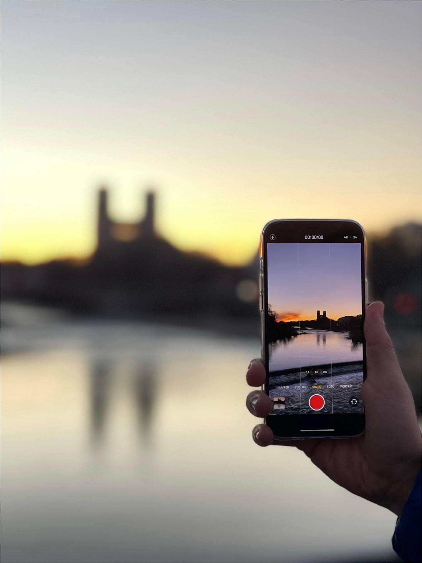 Travel photography without a lot of camera equipment: The video function on a smartphone with a city's evening skyline on the display.