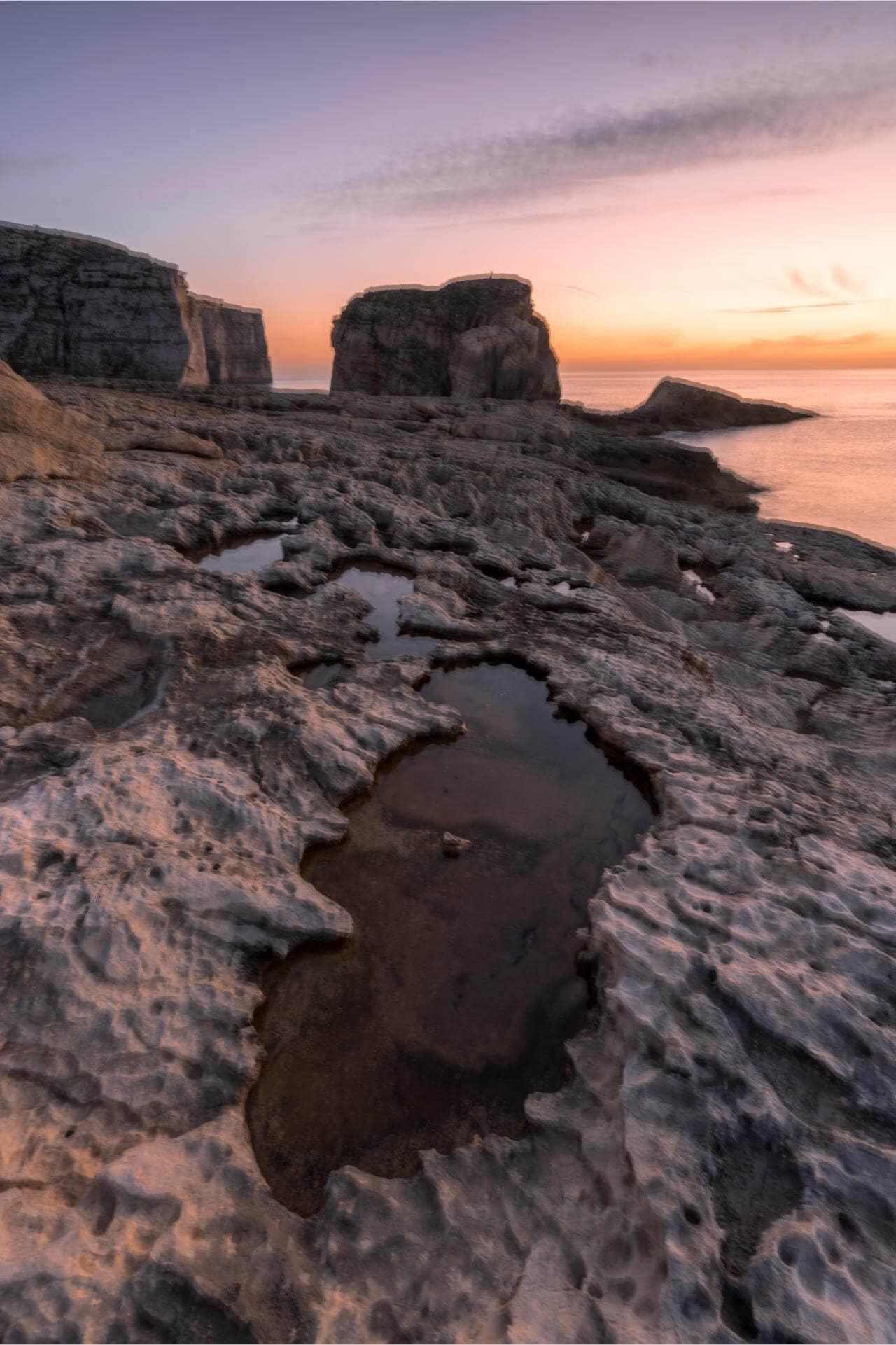 What won't happen to you with our travel photography tips: A blurry photo of a coastline at dawn.