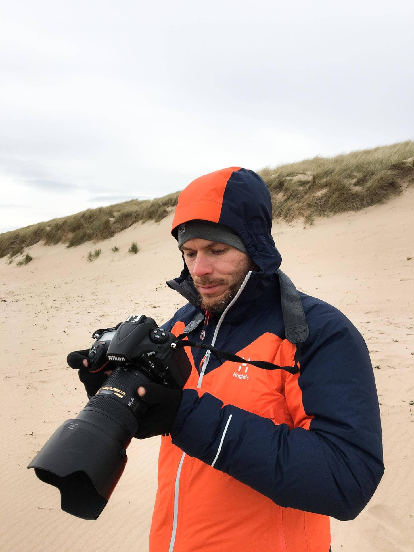 Florian looks at the display of his DSLR while doing travel photography.