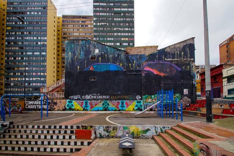 In Bogotá's La Candelaria neighborhood, a sports field has been used for graffiti art amid high-rise buildings.