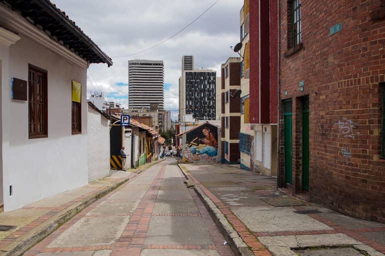 In a narrow alley in Bogotá's La Candelaria neighborhood, we walk downhill past graffiti-covered walls and high-rises.