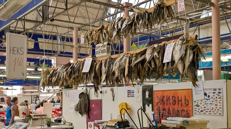 En el mercado central de Riga, en la sala de pescado, los arenques secos se exhiben alineados en largas vigas de madera para la venta.