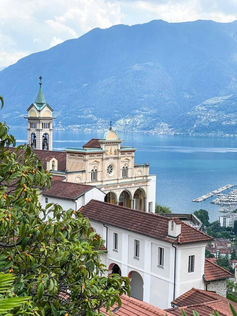 From the Cardada mountain station, you have a beautiful view of the church Madonna del Sasso, the lake behind it, and the mountains.