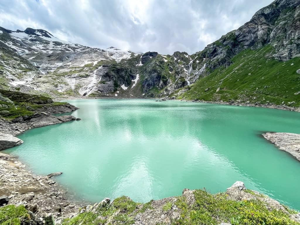 On Lago del Zött, you can admire the turquoise water and mountains while hiking.