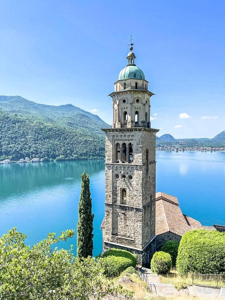 The church tower of Morcote rises over the bright blue Lake Lugano