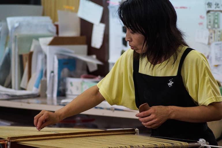 A local weaver at the Minsa Weaving Studio on the Yaeyama island of Ishigaki works diligently on her weaving project.