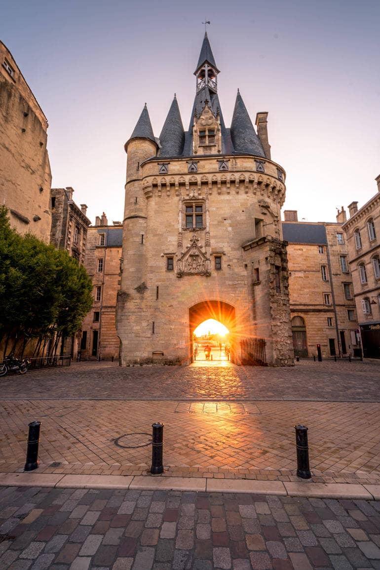 City trip: The rising sun shines through a gate.