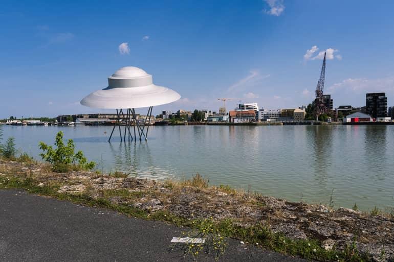 City trip: A spaceship sticking up on stilts in the water.