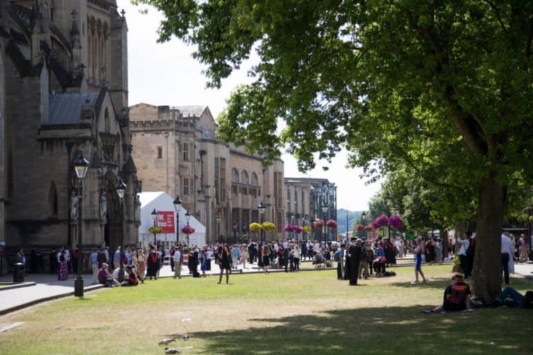 In front of the old brick buildings of the University in Bristol, students celebrate Graduation Day.