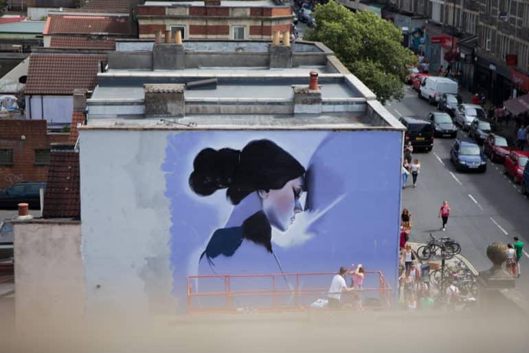 On a building facade in Bristol, England, a woman is drawn in shades of black and blue.