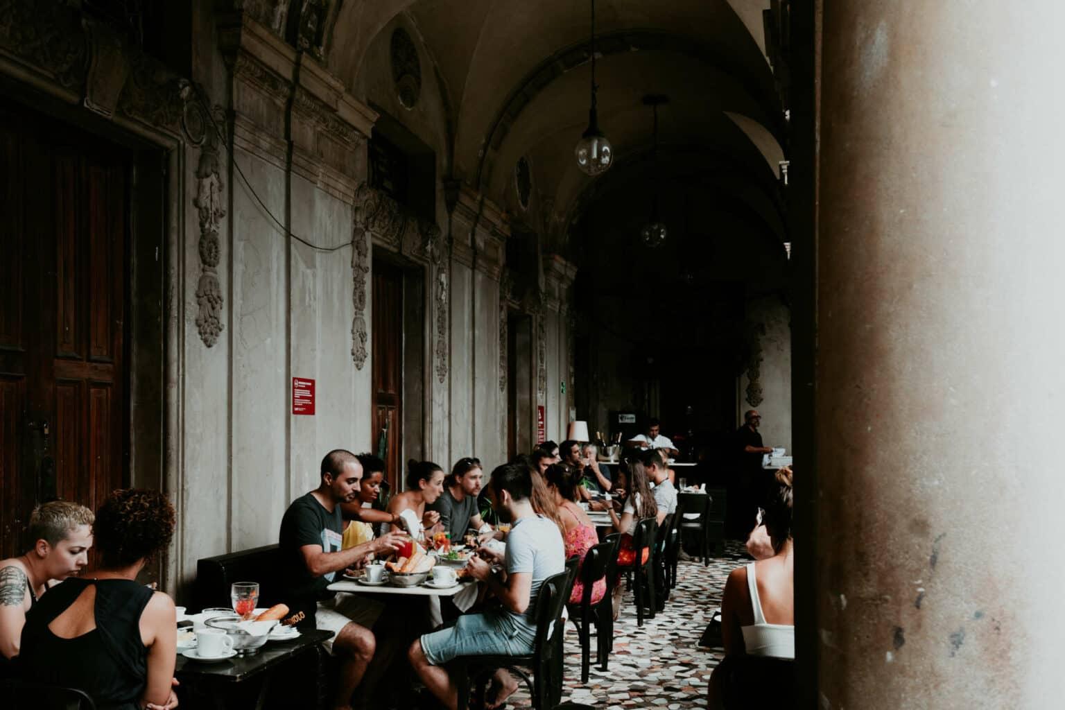 Personas sentadas en mesas en un café.