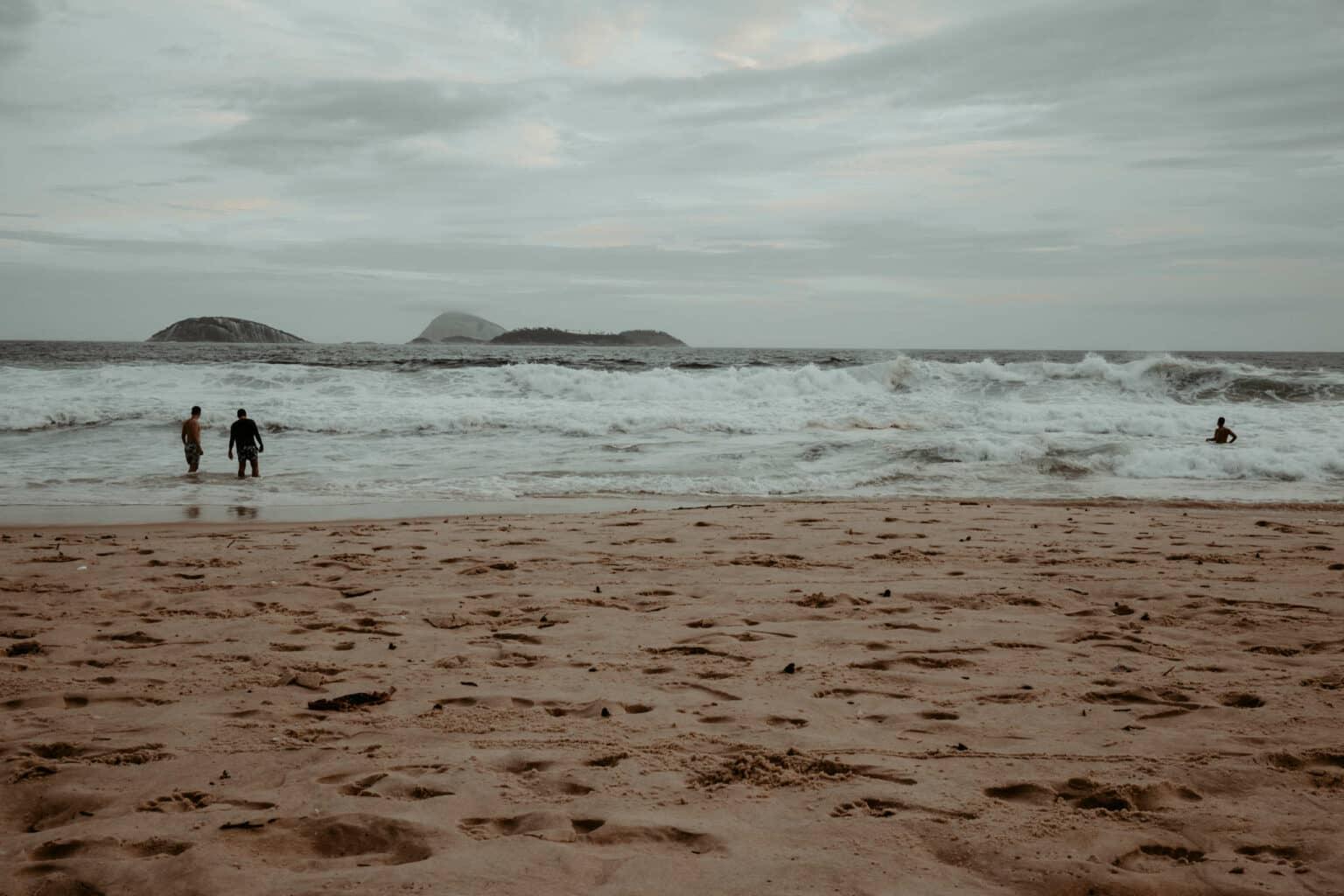 Una playa con personas en el mar.