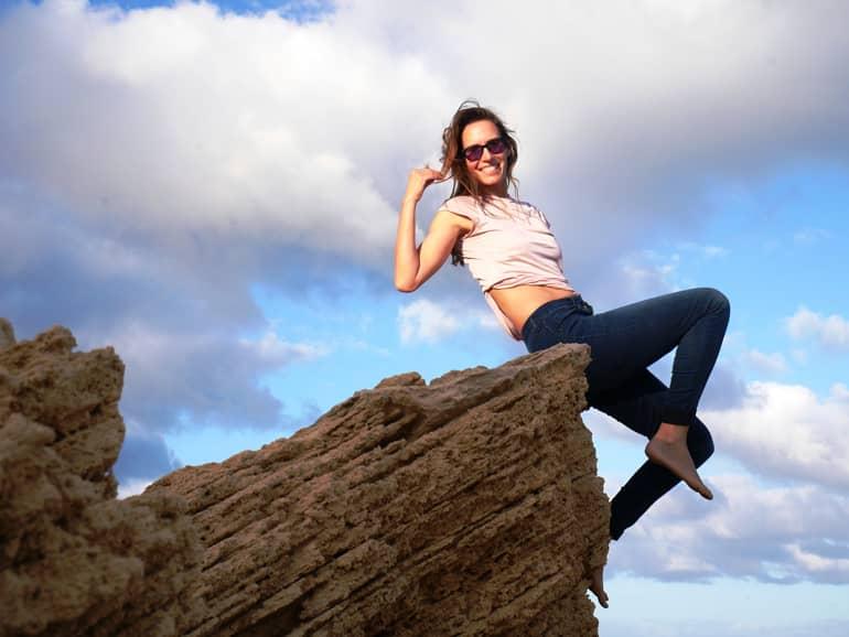 A woman sits on a stone in Madeira.