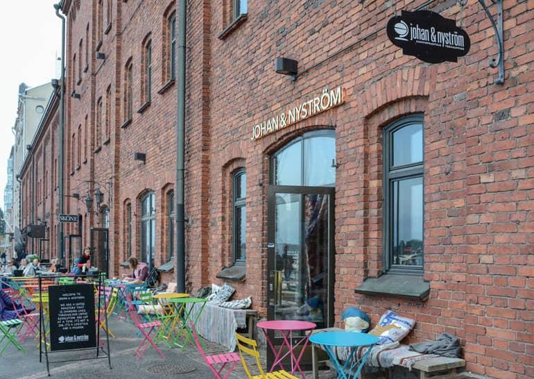 Helsinki: Restaurant with a brick facade and colorful chairs from the outside.
