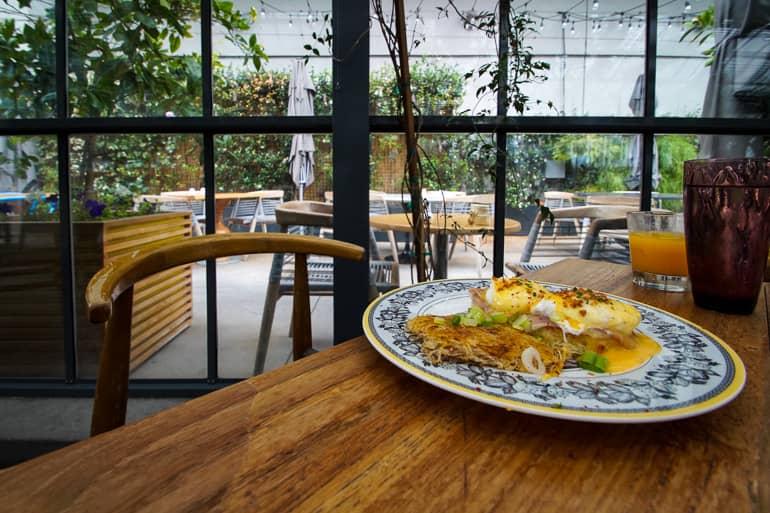 En el Comissary Café en Koreatown, Los Ángeles, se sirve un desayuno fresco y saludable con platos coloridos y servilletas.