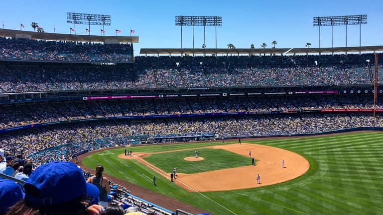 Un partido de béisbol de los L.A. Dodgers contra los Chicago Cubs es seguido con gran expectativa por miles de visitantes.