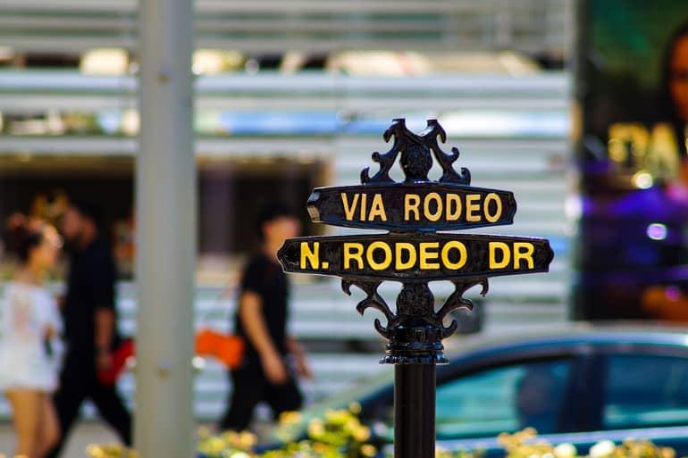 Una señal negra de hierro con letras amarillas que dice Rodeo Drive da la bienvenida a los visitantes de Los Ángeles.