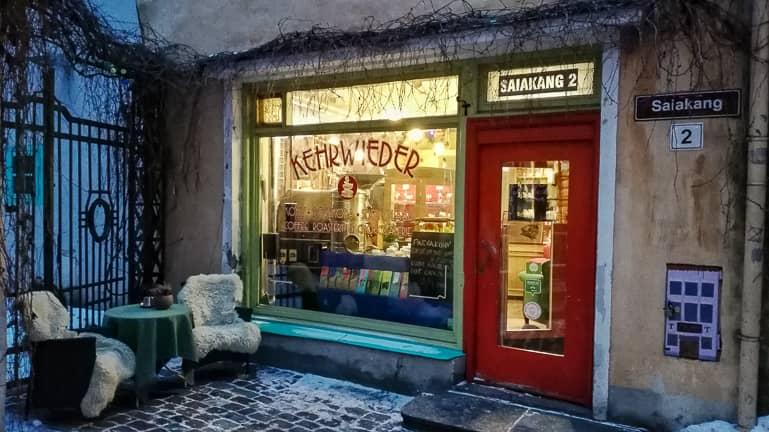 The window display of Café Kehrwieder in Tallinn shows truffle chocolate for sale, with a small seating area in sheepskins by the entrance.