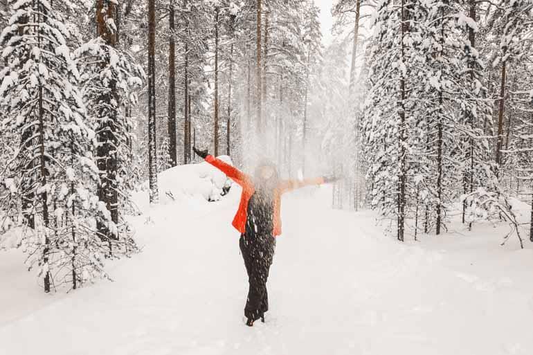A woman stands in a snowy landscape in Finnish Lapland.