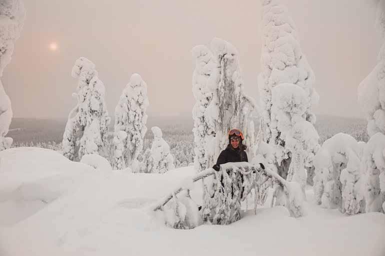 A woman stands in a snowy landscape in Finnish Lapland.