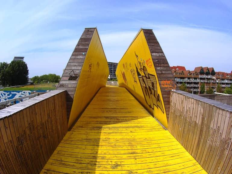 Un puente de madera amarilla llamado Luchtsingel se encuentra en Róterdam y conduce a edificios de apartamentos.